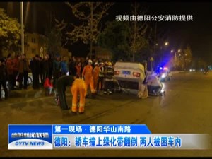 轿车撞上绿化带翻倒 两人被困车内